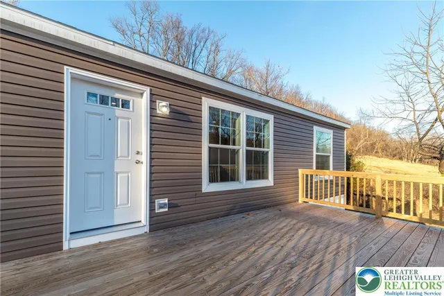 a view of front door with wooden floor and fence