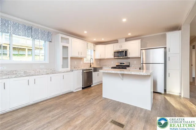 a kitchen with granite countertop white cabinets and white appliances