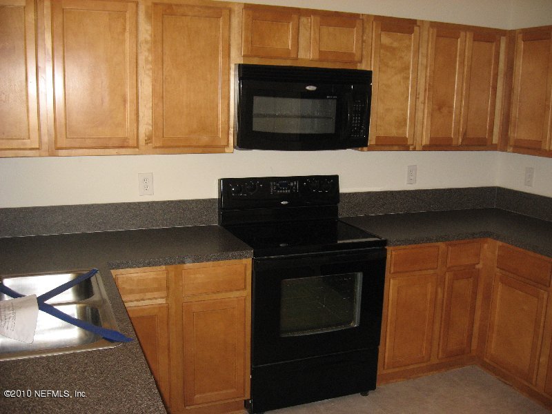 7920 Merrill Road, Unit 602 Jacksonville, FL 32277 - Photo 3 of 12 a kitchen with a sink and a microwave