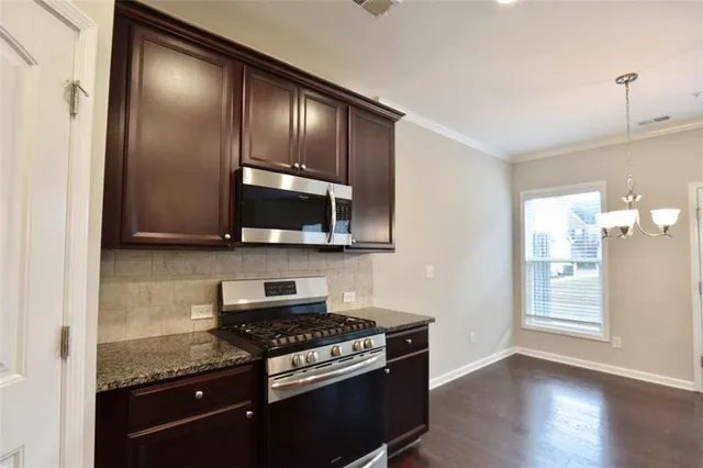 a kitchen with granite countertop stainless steel appliances and wooden cabinets