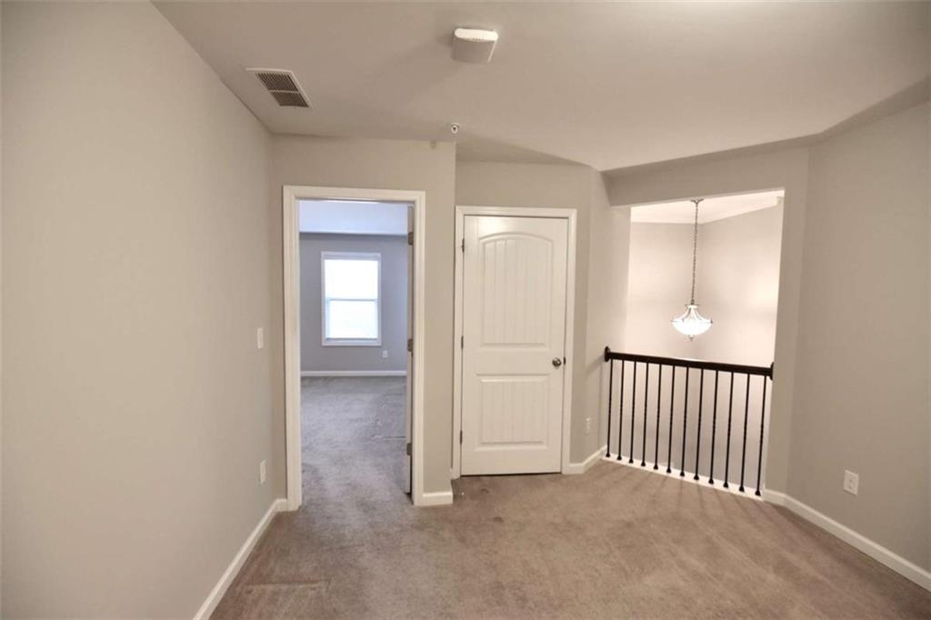 1223 Foxcroft Lane Cumming, GA 30041 - Photo 17 of 33 a view of a hallway with wooden floor and a bathroom