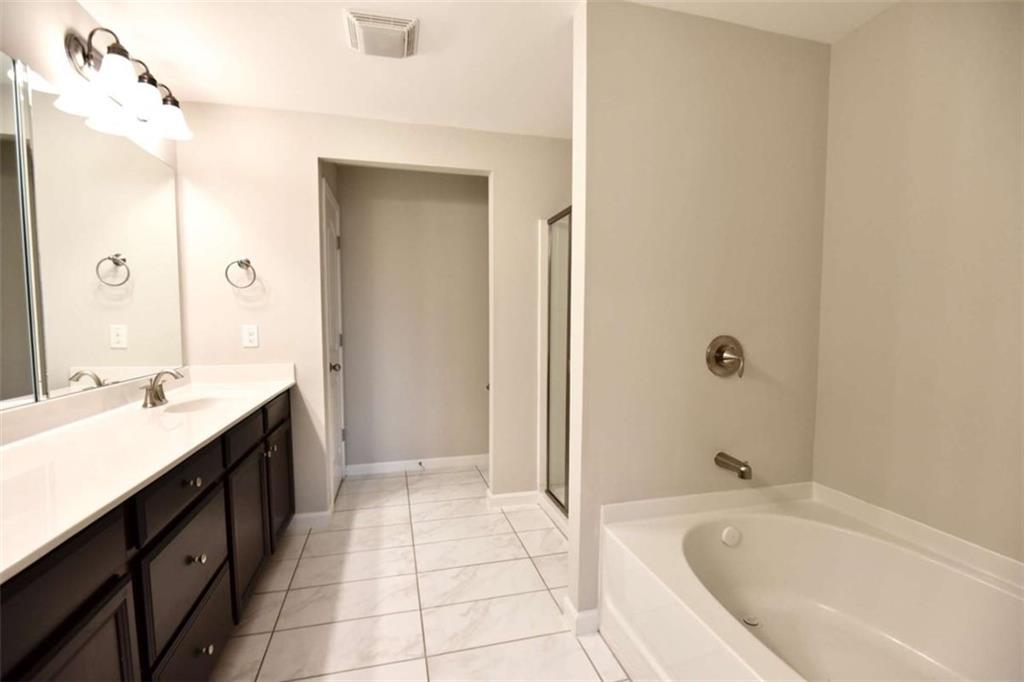 1223 Foxcroft Lane Cumming, GA 30041 - Photo 19 of 33 a spacious bathroom with a tub sink shower and mirror