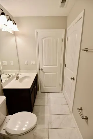 a bathroom with a sink a toilet a mirror and vanity