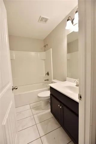 a bathroom with a sink a toilet a mirror and bathtub