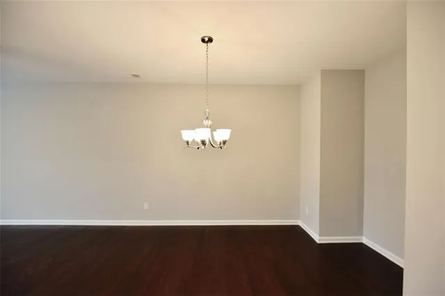 a view of a room with wooden floor and white walls