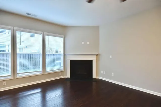 wooden floor fireplace and windows in an empty room