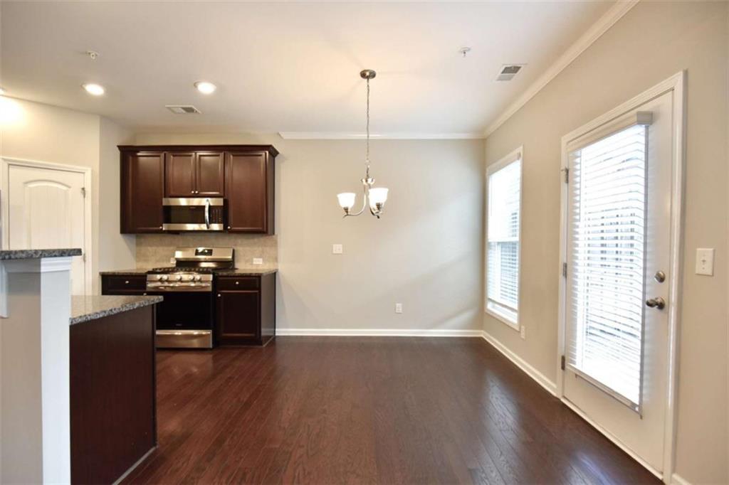 1223 Foxcroft Lane Cumming, GA 30041 - Photo 8 of 33 a kitchen with refrigerator a stove and a wooden floor