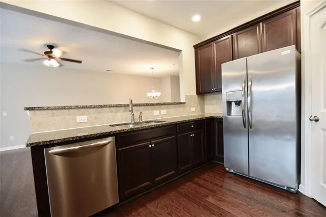 a kitchen with stainless steel appliances granite countertop a refrigerator a sink and dishwasher