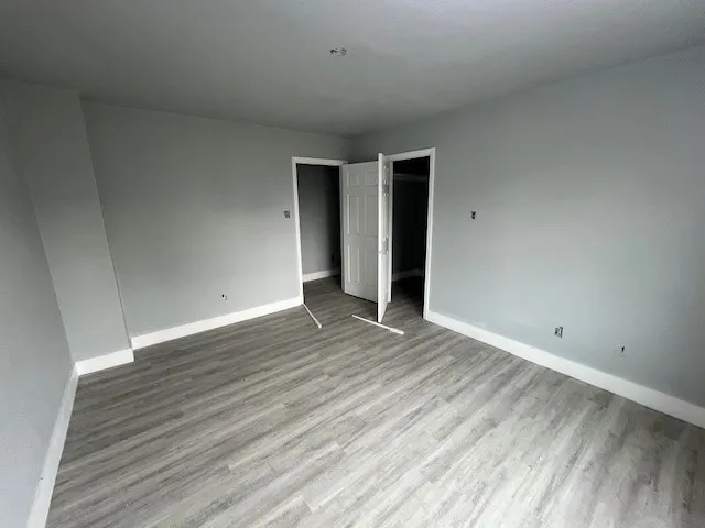 a view of an empty room with wooden floor