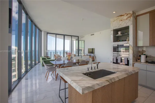 a kitchen with a sink a counter and chairs