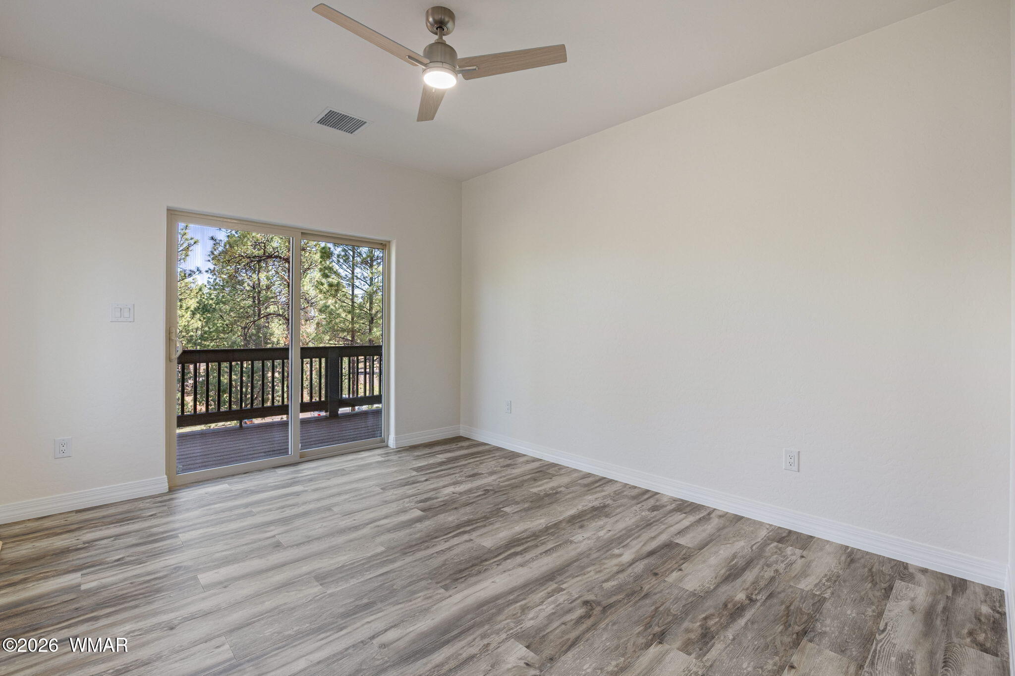 2273 Constellation Lane Overgaard, AZ 85933 - Photo 15 of 31 an empty room with wooden floor fan and windows