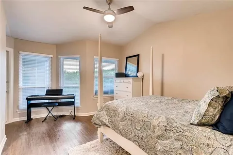 a bedroom with a bed and a wooden floor
