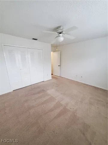 a view of an empty room with a ceiling fan
