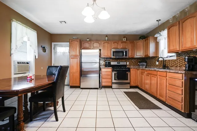 a kitchen with stainless steel appliances granite countertop a refrigerator and a stove top oven
