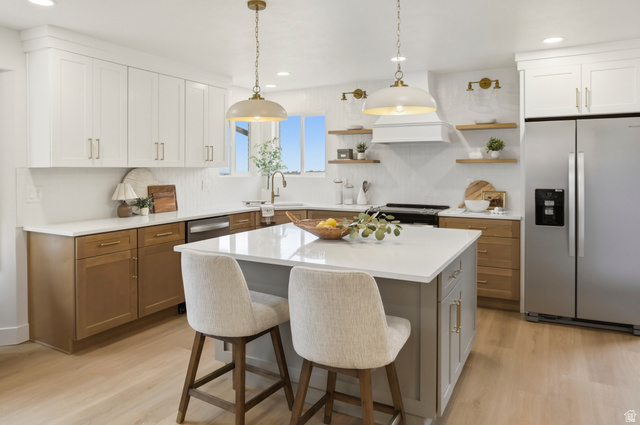 8760 Rustler Road Cottonwood Heights, UT 84093 - Photo 14 of 57 Kitchen featuring white upper cabinetry, natural wood-finish lower cabinetry, and a center island with a white countertop