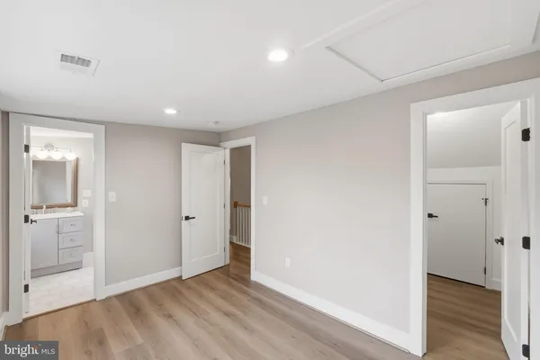 a spacious bathroom with a double vanity sink a toilet and a mirror