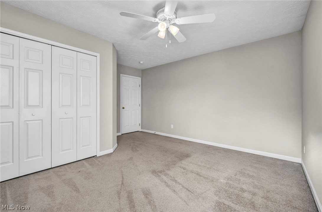 147 Stone Ridge Way Berea, OH 44017 - Photo 31 of 44 Unfurnished bedroom featuring light colored carpet, a closet, ceiling fan, and a textured ceiling