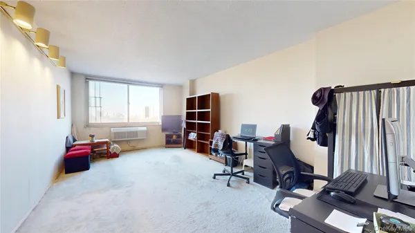 a view of a livingroom with workspace and a window