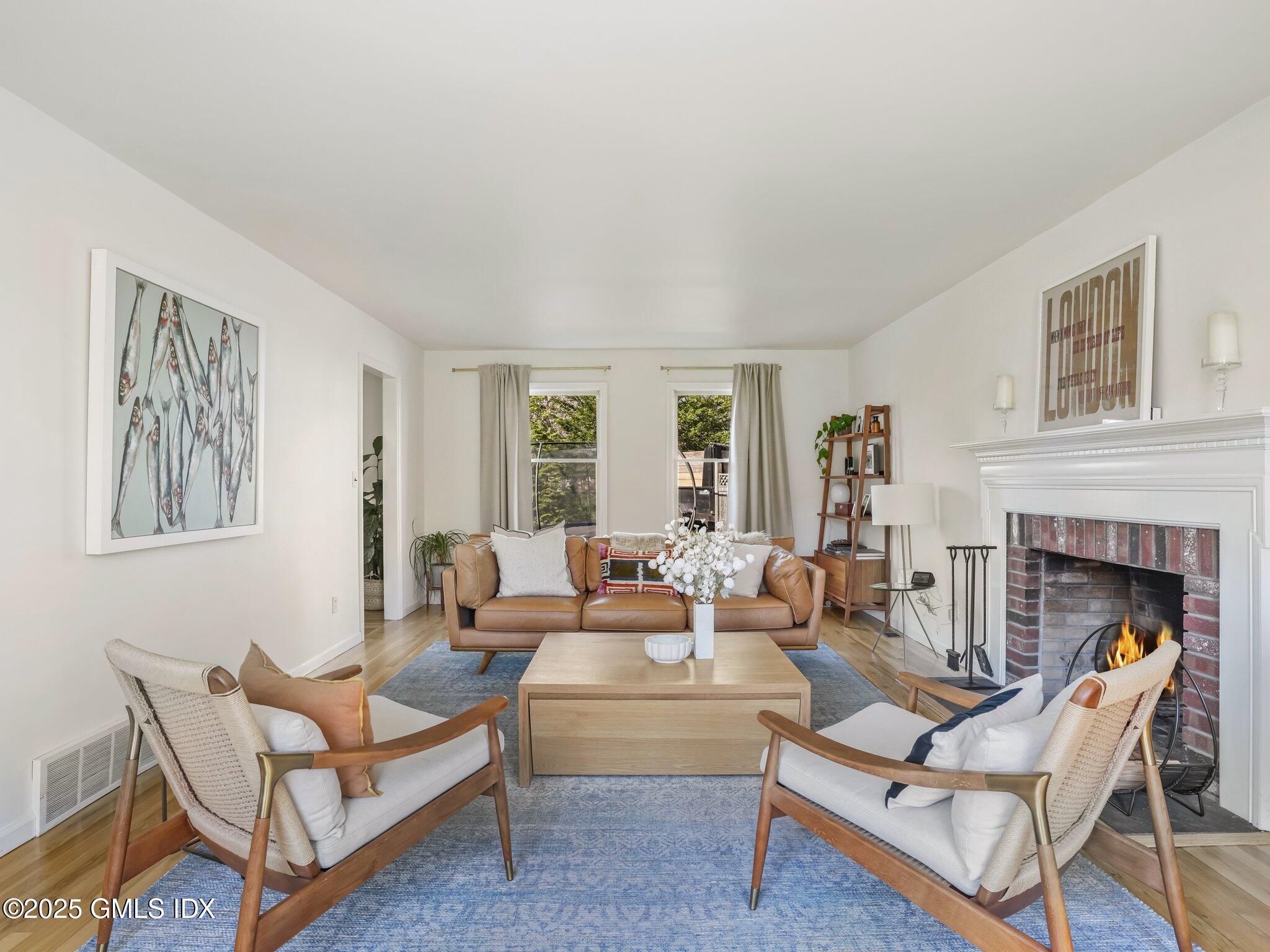 6 Coventry Lane Riverside, CT 06878 - Photo 6 of 18 a living room with furniture a fireplace and a large window
