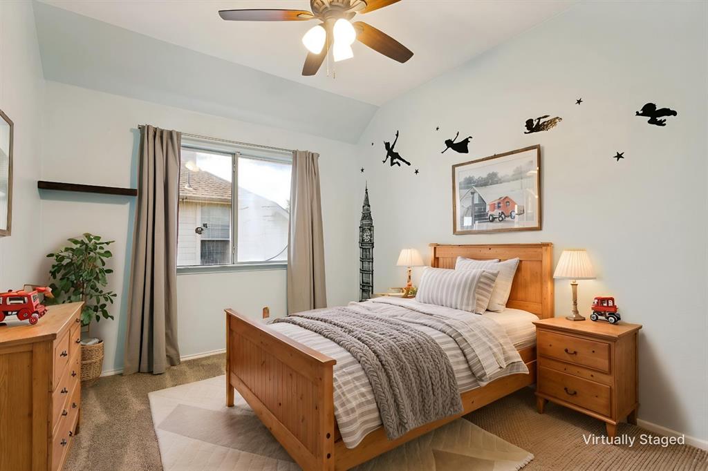 4107 Waverly Road Corinth, TX 76208 - Photo 23 of 30 The third bedroom upstairs features a soft wall color, neutral carpet, an upgraded ceiling fan, and a nod to Peter Pan with the wall accents.