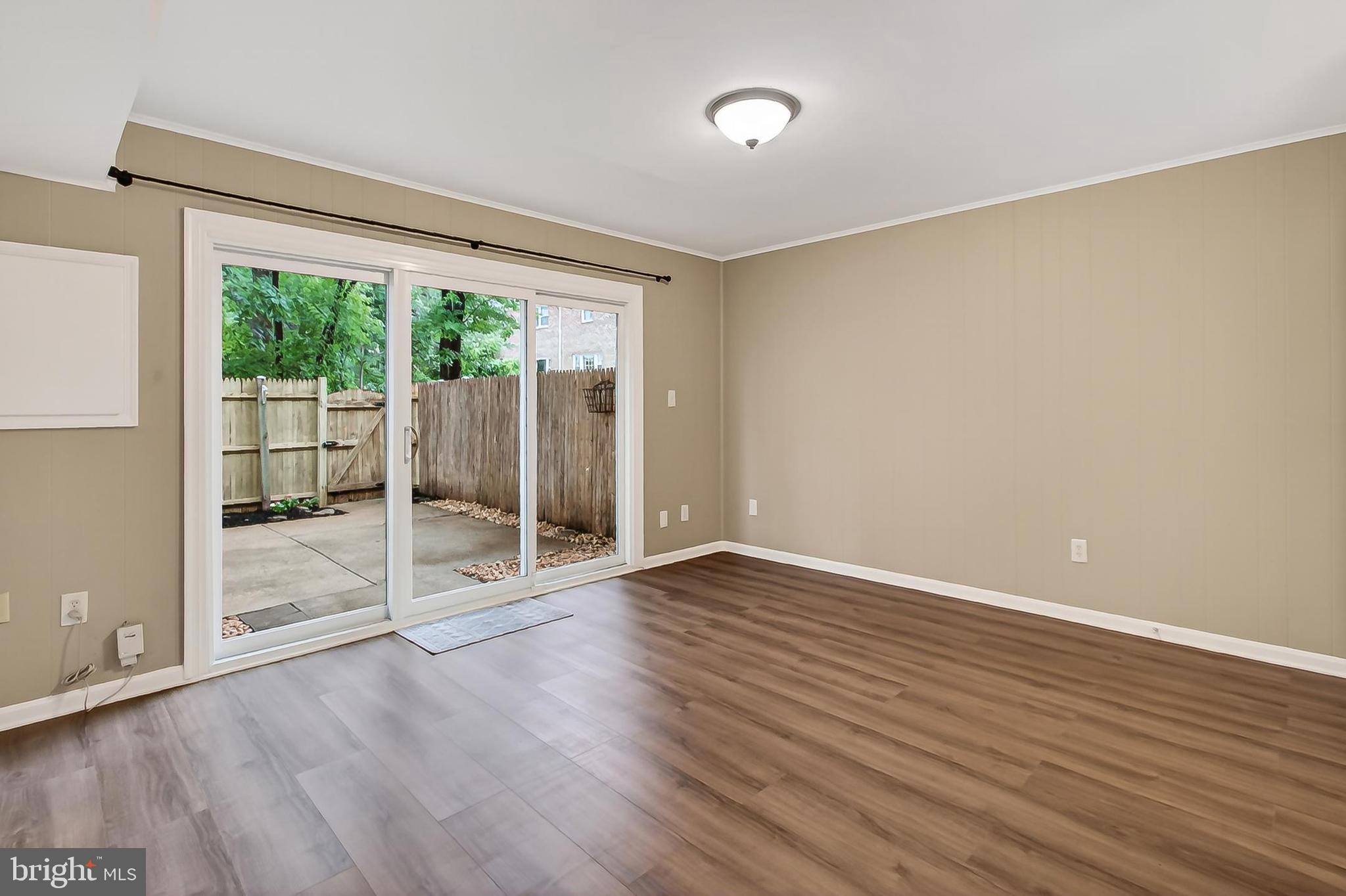 5833 Royal Ridge Drive, Unit 943 Springfield, VA 22152 - Photo 32 of 45 an empty room with wooden floor and windows