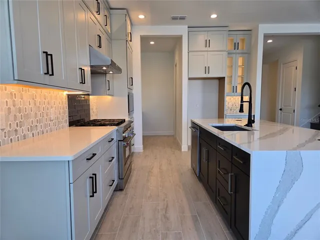 a kitchen with stainless steel appliances granite countertop a large counter top cabinets and wooden floor