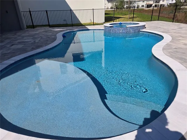 a spacious bathroom with a double vanity sink a mirror and a bathtub