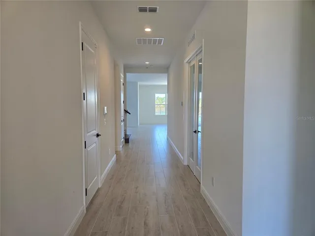 a view of a hallway with wooden floor