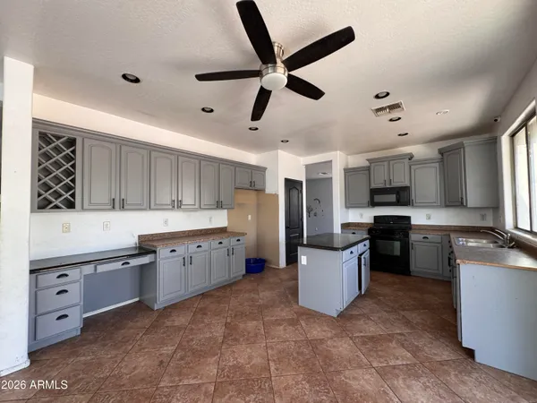 a view of a livingroom with a ceiling fan a ceiling fan and kitchen view