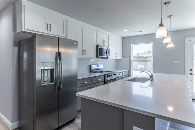 a kitchen with stainless steel appliances a refrigerator sink and stove