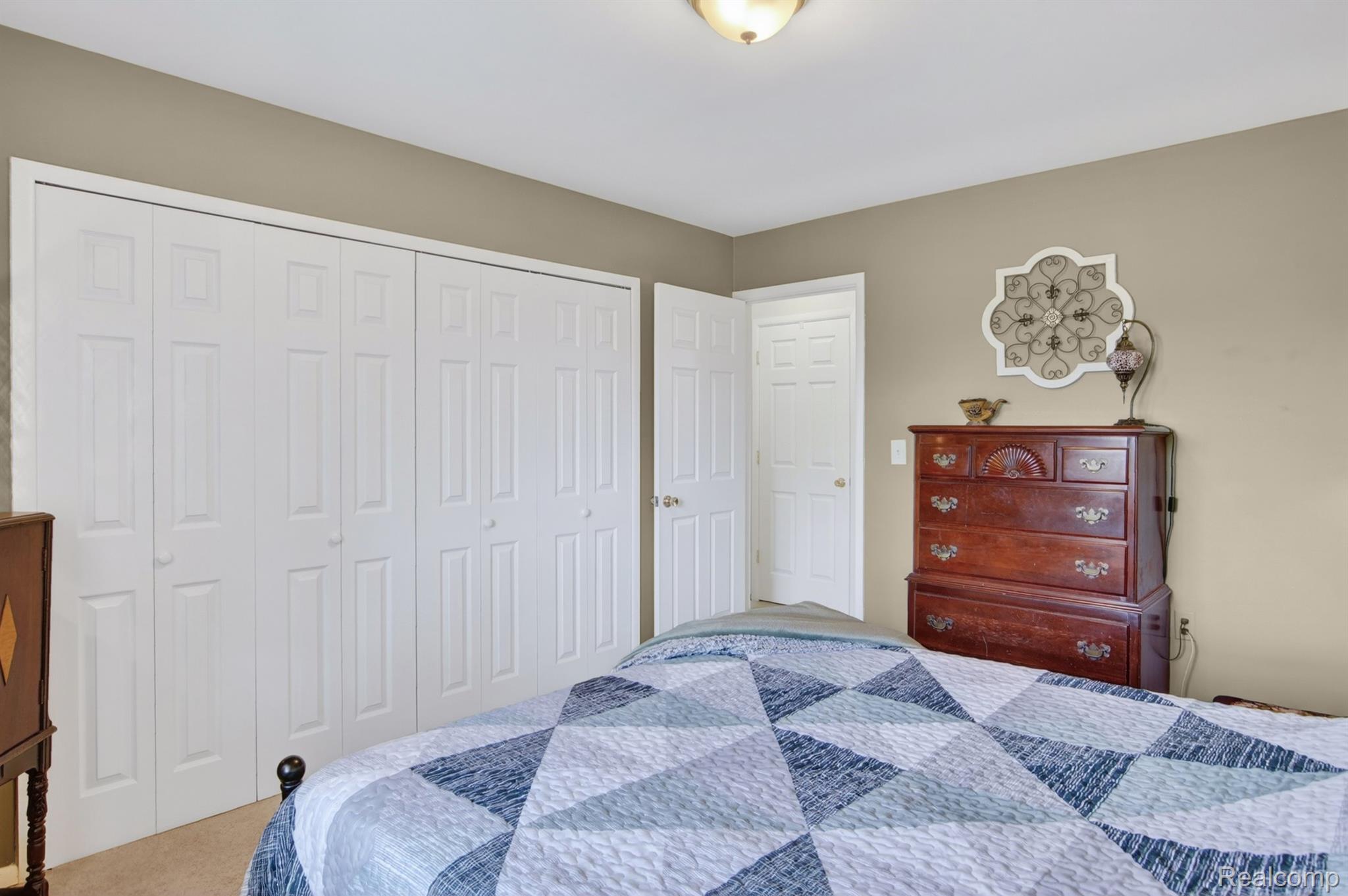 24111 Meridian Road, Unit 116 Grosse Ile, MI 48138 - Photo 16 of 26 Neutral wall paint, white trim, and white bi-fold closet doors