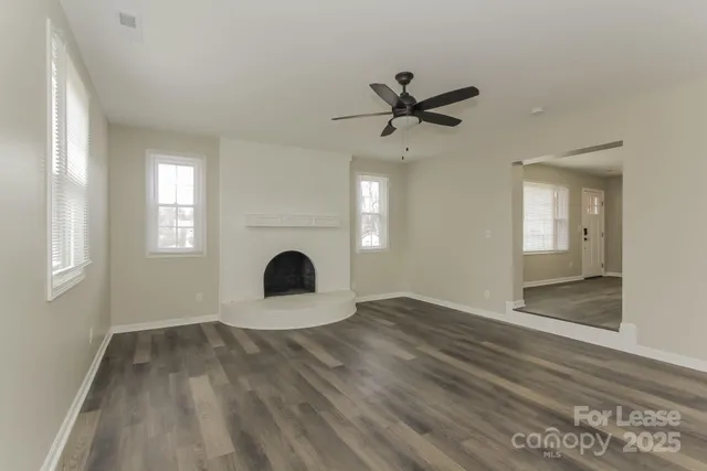 a view of a big room with wooden floor and windows