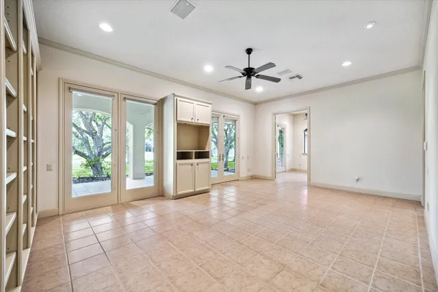a view of a livingroom with a chandelier fan and windows