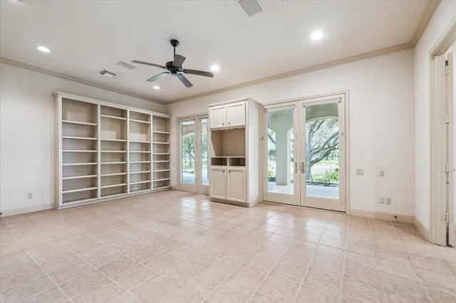 a view of an empty room with a window and a kitchen