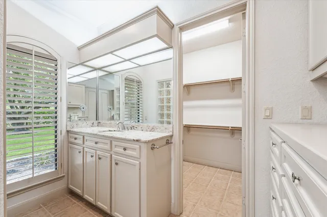 a bathroom with a granite countertop sink and a mirror