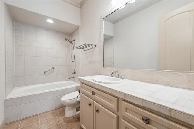 a bathroom with a granite countertop sink a toilet a mirror and bathtub