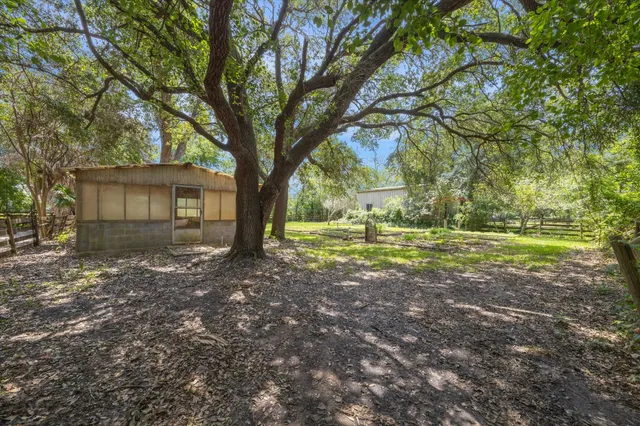 a view of a house with backyard and trees