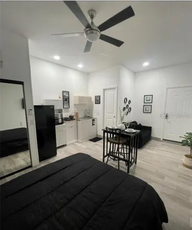 a living room with stainless steel appliances furniture and a table