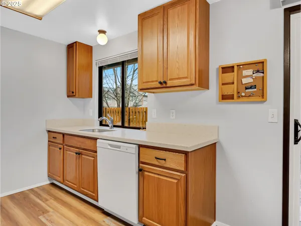 a kitchen with stainless steel appliances granite countertop a sink and cabinets with wooden floor
