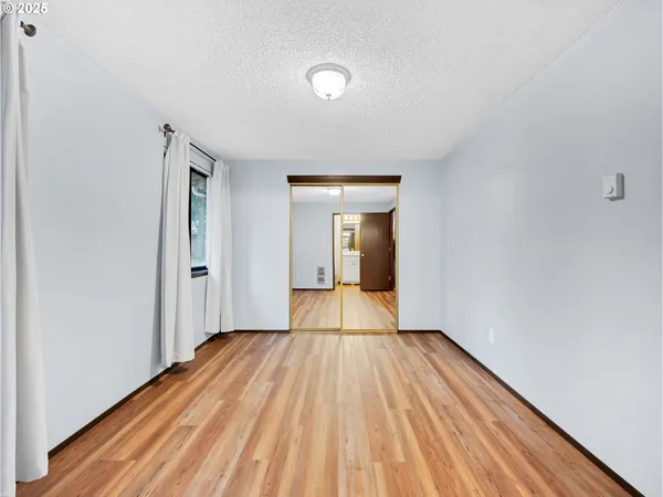 a view of a room with wooden floor and natural light