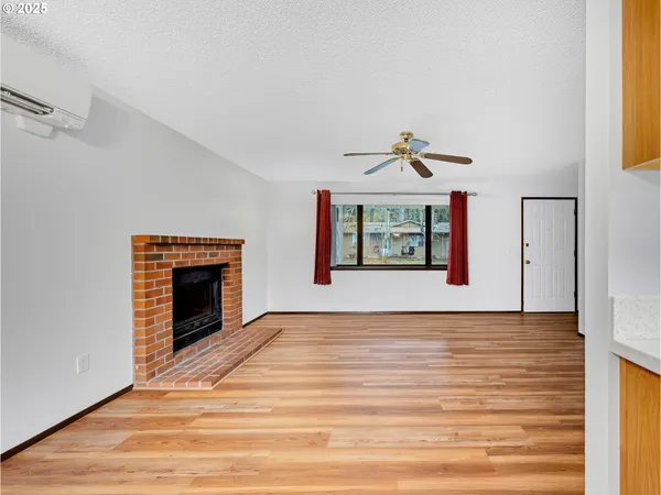 a view of an empty room with a window and a fireplace