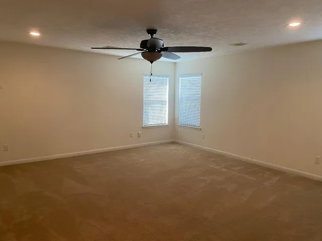 a view of an empty room and a ceiling fan