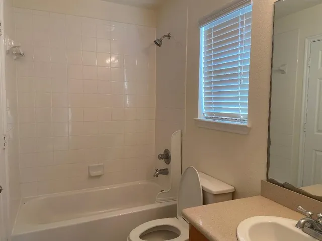a bathroom with a granite countertop toilet a sink and bathtub