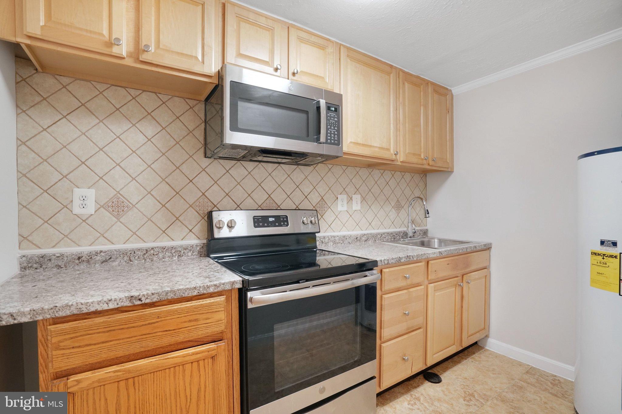 3412 Knox Road Annandale, VA 22003 - Photo 38 of 54 a kitchen with stainless steel appliances granite countertop white cabinets and a stove top oven