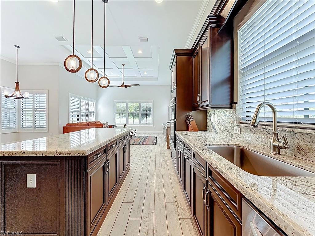 5550 Ferrari Avenue Ave Maria, FL 34142 - Photo 20 of 50 a kitchen with stainless steel appliances granite countertop a sink a stove and a wooden floors