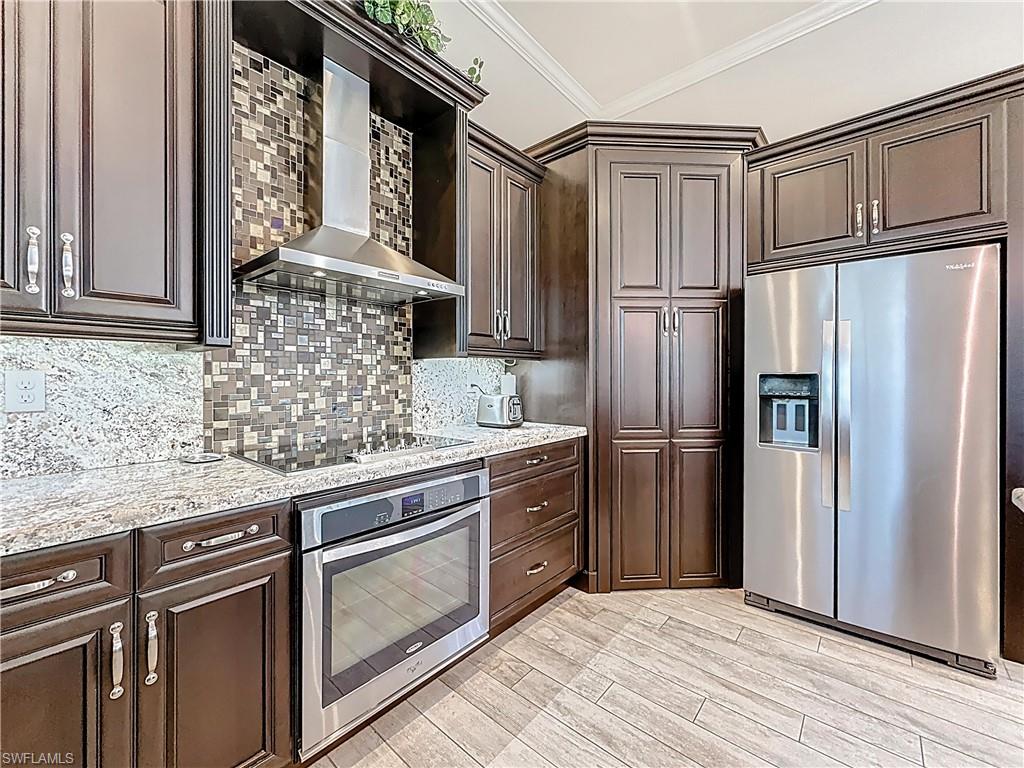 5550 Ferrari Avenue Ave Maria, FL 34142 - Photo 21 of 50 a kitchen with stainless steel appliances granite countertop a refrigerator sink and cabinets