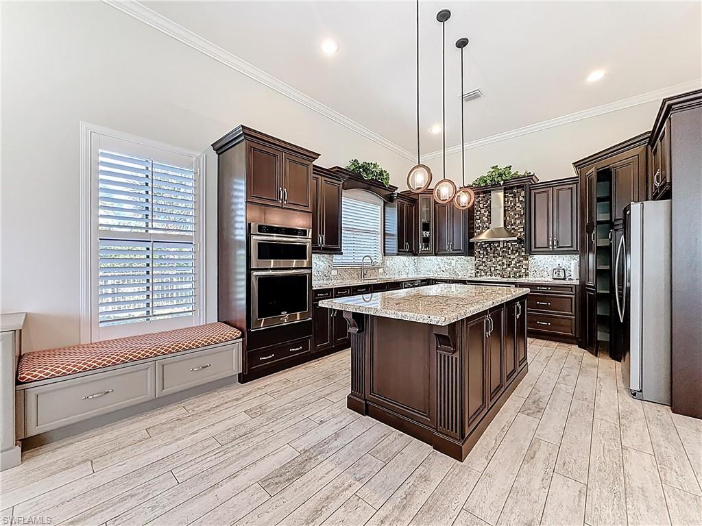 5550 Ferrari Avenue Ave Maria, FL 34142 - Photo 23 of 50 a kitchen with stainless steel appliances granite countertop a kitchen island a stove and a wooden floors
