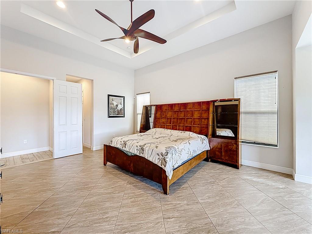 5550 Ferrari Avenue Ave Maria, FL 34142 - Photo 25 of 50 a bedroom with a large bed and a ceiling fan