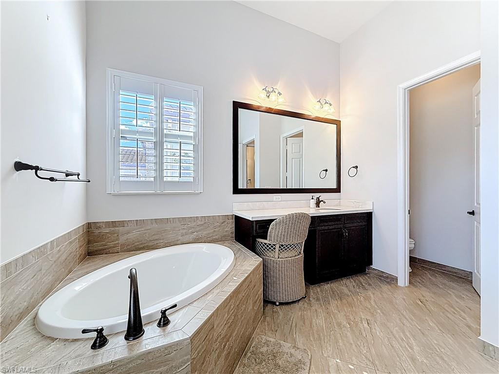 5550 Ferrari Avenue Ave Maria, FL 34142 - Photo 31 of 50 a bathroom with a tub sink and mirror