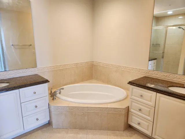 a bathroom with a granite countertop sink and a bathtub